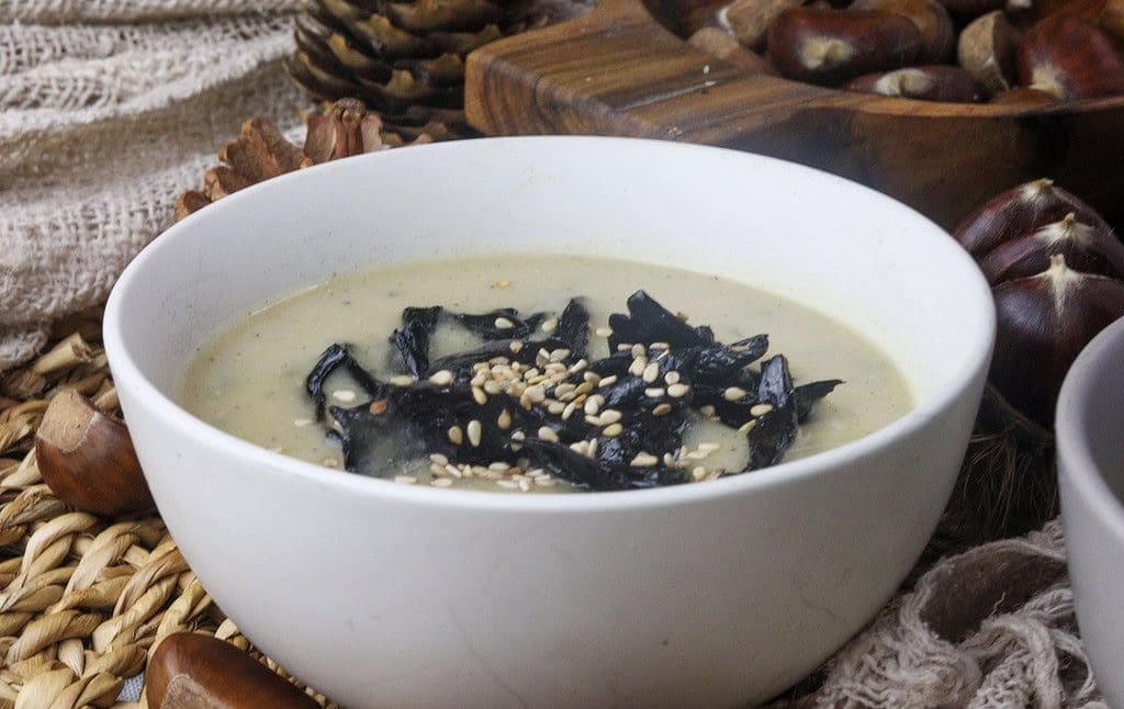 culinary representation of a pear potato black trumpet soup with sesame seeds